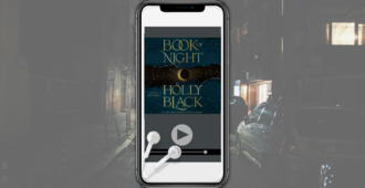 Book of Night cover on an iPhone plus headphones over a dark city street background