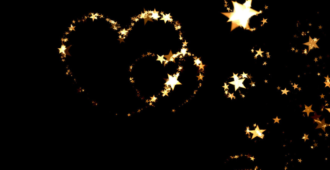 A glittering gold heart made out of small stars set against a black background. Toward the right boundary, the hearts sort of unwind into a star spiral