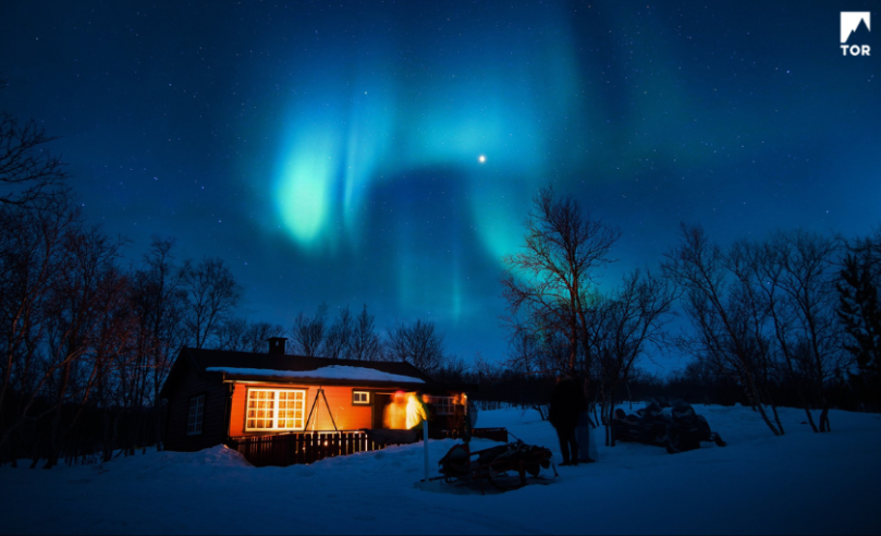 Cozy cabin under an icy blue aurora