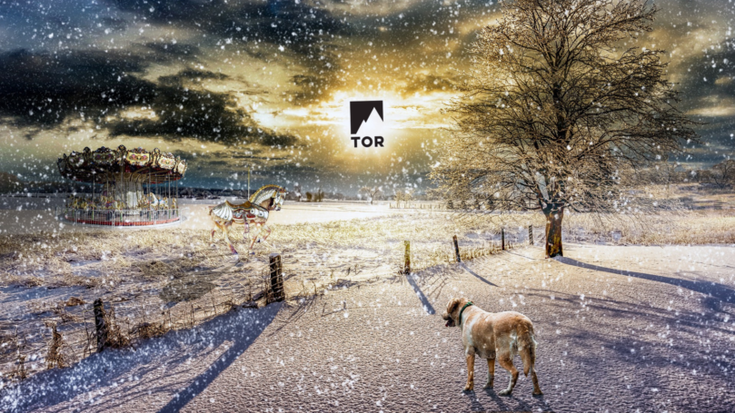 Goat in winter wonderland with carousel in background looking at a distance sun that's also the tor books logo
