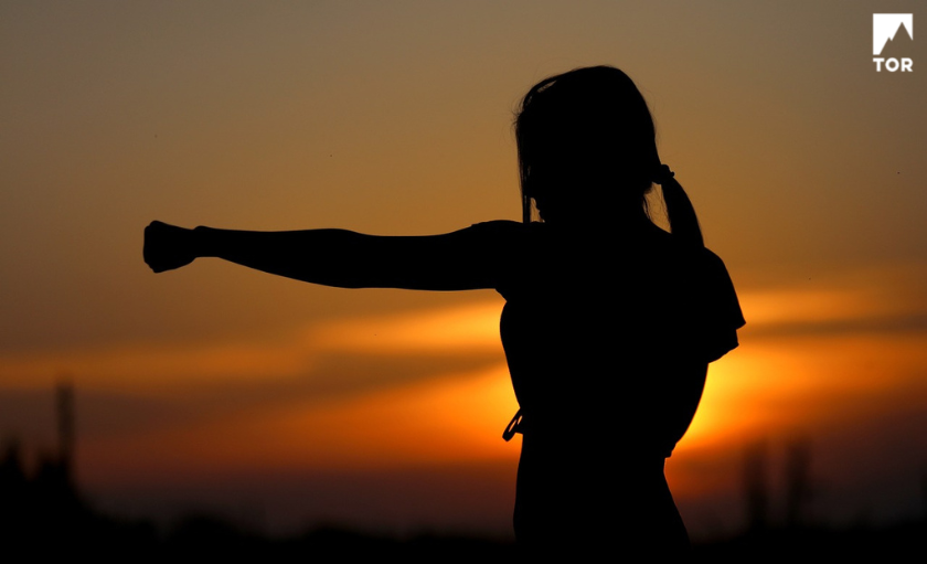 the shadow of a woman punching with sunset background